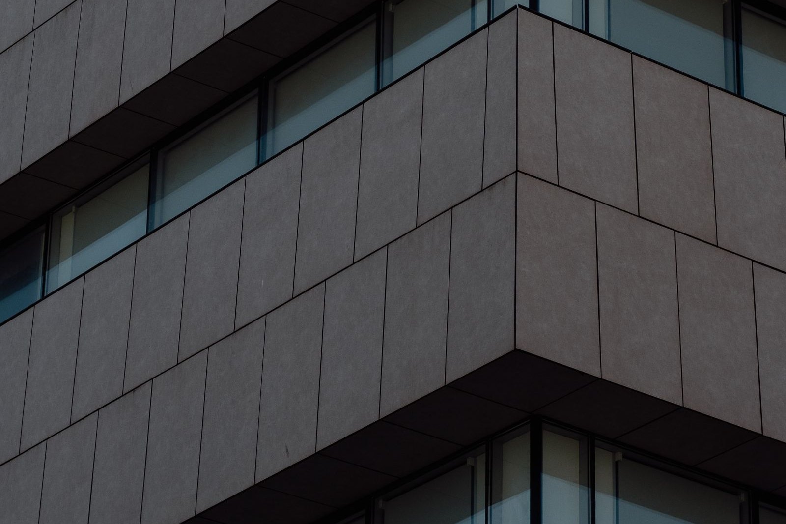 Repeating window bays across the face of a dark commercial building