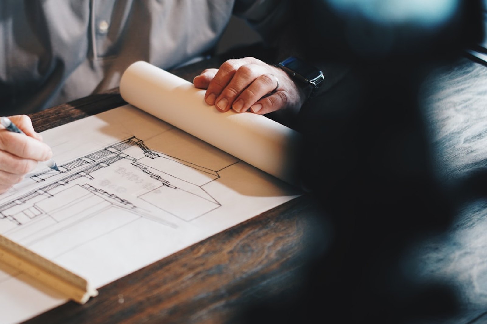 Architectural drawing held flat on a work table beside a straight edge