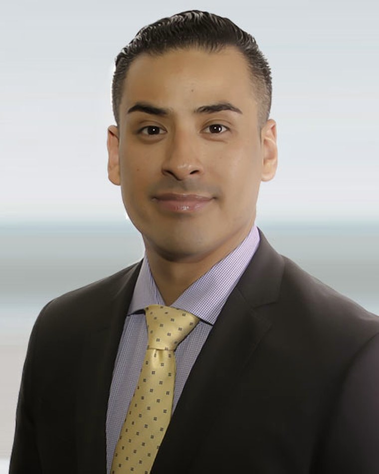 Luis Amen, founder of OC Private Money, in a dark suit against a softly lit office window