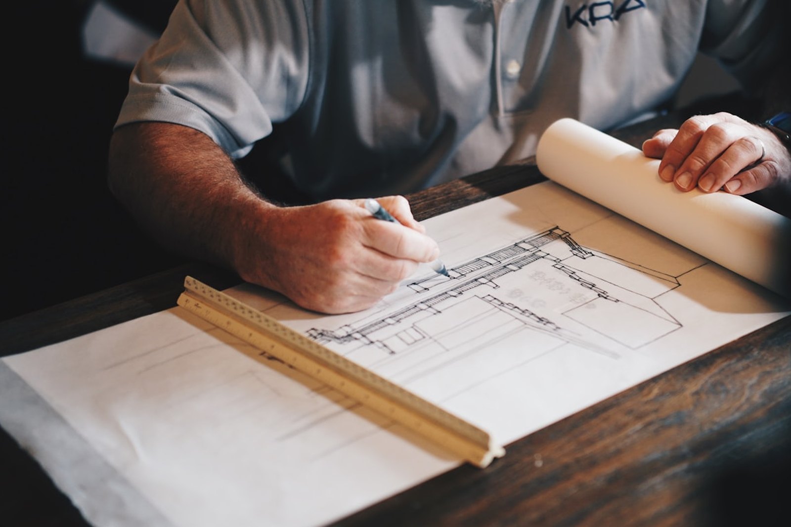 Architectural plan unrolled on a timber workbench during a project review